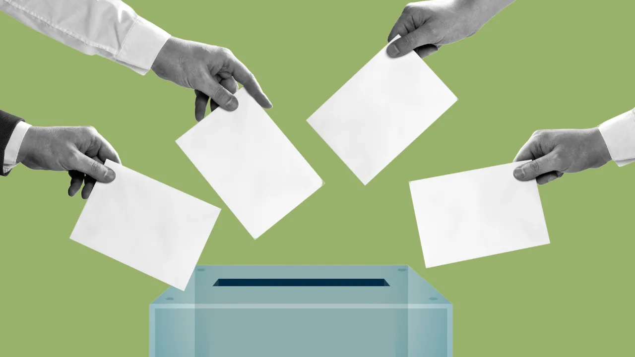 Imagem de várias mãos a colocar o voto na urna