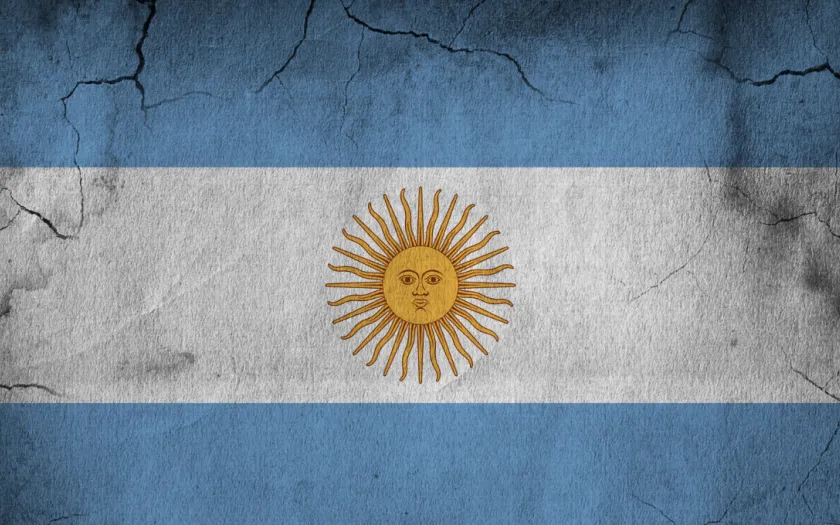 Imagem da bandeira da Argentina numa parede parcialmente destruída