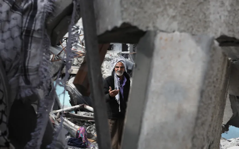 Imagem de um palestiniano nos escombros da sua casa em Rafah, Faixa de Gaza. Crédito Shutterstock.