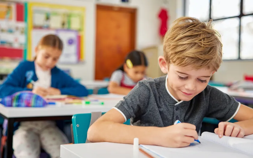 Alunos do ensino básico na sala de aula a fazer testes. Crédito:Shutterstock