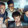 Imagem de um grupo de jovens a ver programação informática