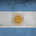 Imagem da bandeira da Argentina numa parede parcialmente destruída