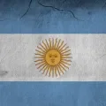 Imagem da bandeira da Argentina numa parede parcialmente destruída