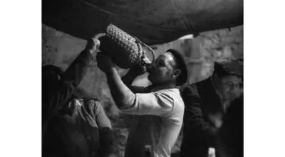 Imagem de um homem a beber do garrafão em Amieira dos Gatos, 1980. Crédito: Nuno Félix da Costa.