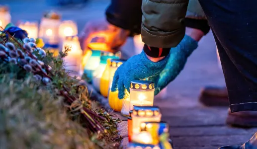 Imagem de uma pessoa a colocar velas em memória dos mortos