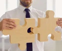 Imagem de um empresário a juntar as peças de um puzzle