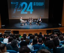 Imagem do auditório da Escola Secundária de Camões, em Lisboa, com Hugo van der Ding a moderar a conversa entre os alunos, Mónica Vieira, e o economista Pedro Freitas